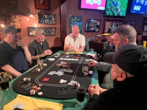 A group of people playing a social game of Texas Hold'em at a free poker Vancouver event held at The Village Pub.