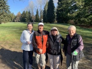 Four women smiling together on the fairway at Kensington Park Pitch and Putt social golf Burnaby