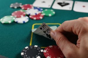 Hand holding two kings over a poker table with chips at a Metro Vancouver poker game