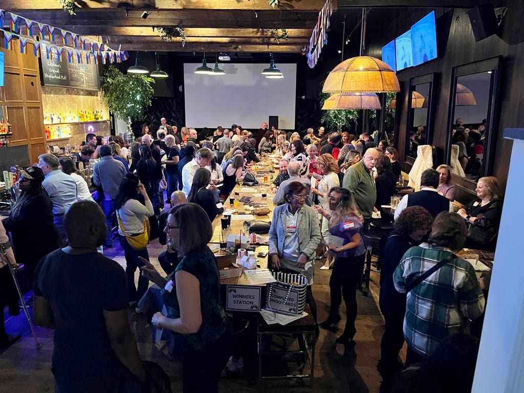 Crowd of attendees mingling and playing bingo at a Vancouver Social Events pub night, the kind of relaxed group setting that draws an over 50 singles Vancouver crowd