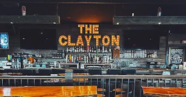 The Clayton Public House bar in Clayton Heights, Surrey, with its lit-up Clayton sign